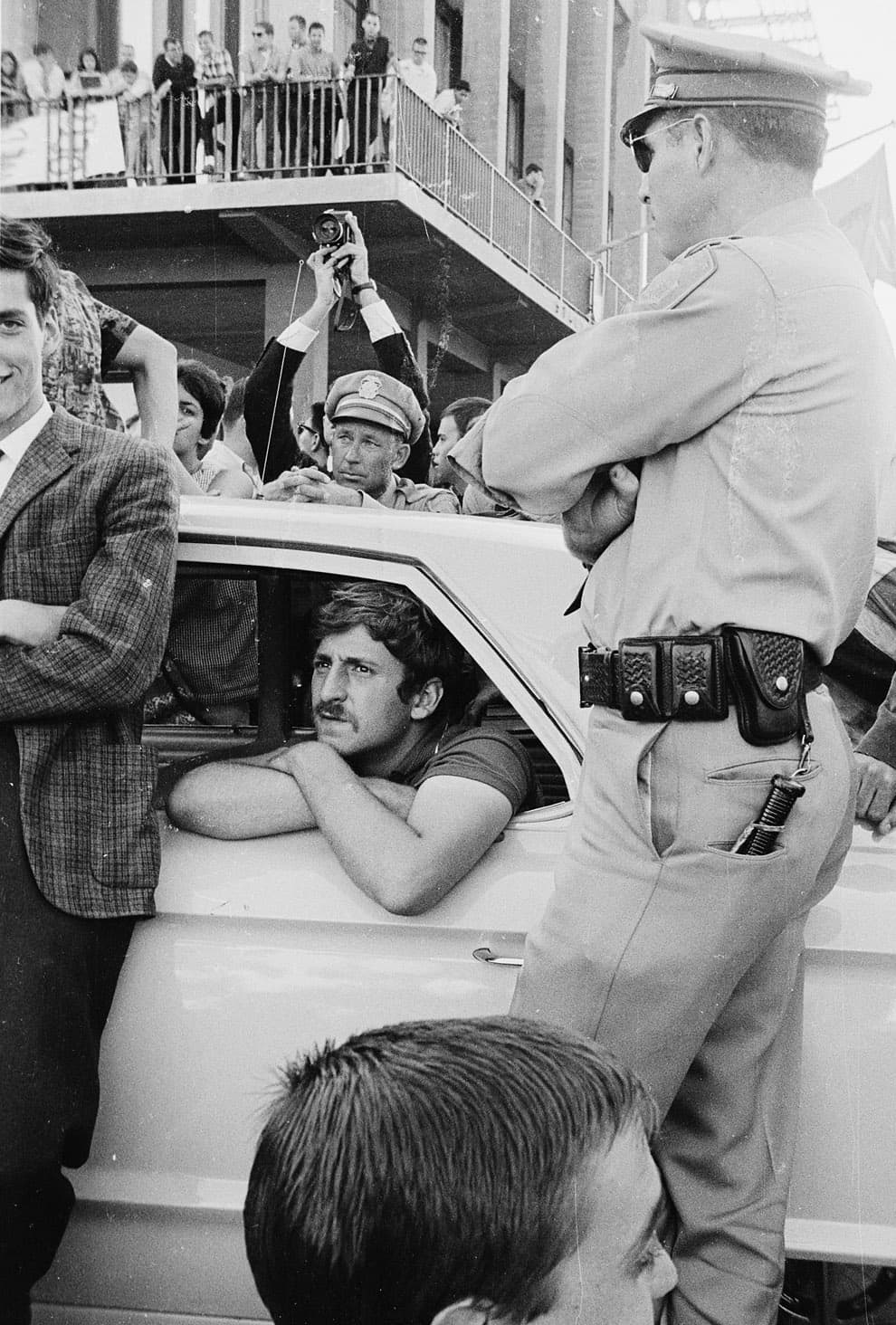 Jack Weinberg in police car surrounded by students during the 32-hour sit-in